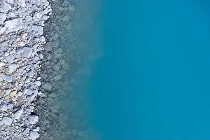 Aerial top view of turquoise lake and rocks abstract background at Tekapo, New Zealand