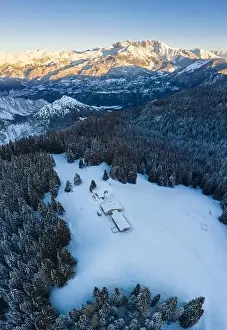 Seriana Valley Prints: Aerial view of the Valmezzana hut and Presolana massif during a winter sunrise from Monte Pora