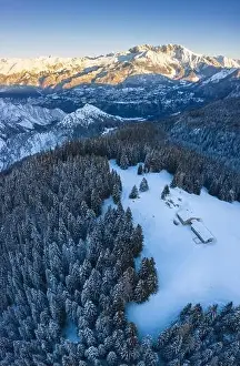 Seriana Valley Prints: Aerial view of the Valmezzana hut and Presolana massif during a winter sunrise from Monte Pora