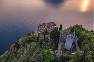 Aerial view of Vezio Castle and Varenna village in background during summer sunset