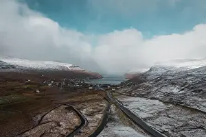 Aerial view of the village Sorvagur during a helicopter flight over the snow-covered landscape of the islands Vagar in