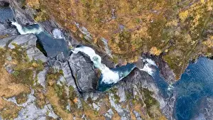Vale Prints: Aerial view of a waterfall cascading through rocky terrain surrounded by autumn foliage