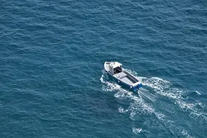 Motorboat Prints: Aerial view of a white fishing boat on a blue clear sea water