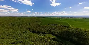 Aerial wide panoramic view of dark mountain hills covered with green mixed pine and lush forest in evening