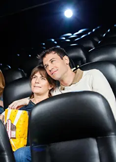 Heterosexual Prints: Affectionate Couple Watching Film In Theater