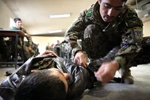 Airforce Prints: An Afghan National Army infantry officer with the 203rd Corps applies a tourniquet to a simulated casualty during a