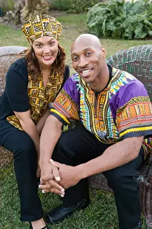 Traditional Attire Prints: African American couple dressed in traditional African attire sitting outdoors