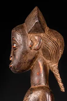 Masks Prints: An African female statue carved in wood isolated on black