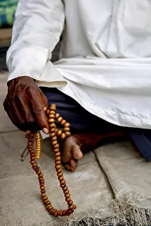 Cote Divoire Prints: African muslim holding prayer beads in Abidjan, Ivory Coast