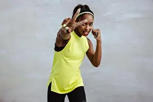 Boxer Prints: African woman in fitness wear showing peace sign with her hand during workout
