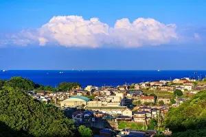Kansai Prints: Afternoon sun hits small coastal village as clouds billow in distance