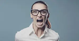 Executive Prints: Aggressive angry woman shouting at camera, she is feeling furious and frustrated
