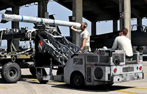 Armament Prints: Aircraft maintenance teams employ a lift truck to move an AIM‑120 advanced medium‑range air‑to‑air missile toward an