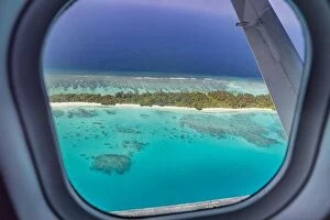 Images Dated 3rd February 2022: Airplane window with beautiful Maldives island view. Luxury summer holiday travel tourism background