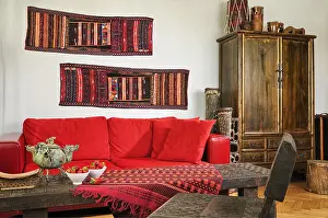 Cushion Prints: Akha tribe wall runners above red leather in ethnic style living room UK AND IRISH RIGHTS ONLY