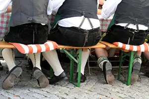 Cushion Prints: At the bottom of it all three men sitting comfortably on a bench during a Bavarian celebration Bavaria Germany