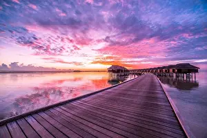 Amazing abstract background. Beautiful sunset colors in Maldives. Long jetty and luxury overwater villas