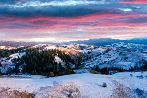 Amazing aerial view of mountains range and meadows of the countryside in spring time. Dramatic sky