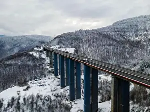 Forest Mountain Prints: Amazing aerial view of a road. Stunning snow landscape with river and trees