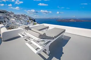 Amazing destination scenic. Two chairs umbrella on caldera terrace in Santorini, Greece. White famous architecture, blue sea sky view. Honeymoon