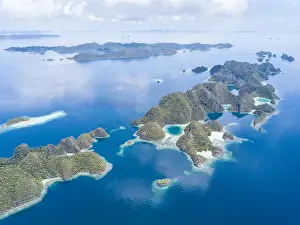 Amazing limestone islands rise from the calm seascape around Misool, Raja Ampat, Indonesia. This tropical region harbors amazing marine biodiversity