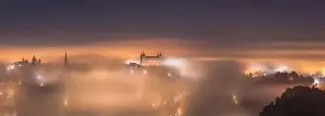 Amazing scenery of shining and luminous ancient Alcazar de Toledo castle over town in misty twilight