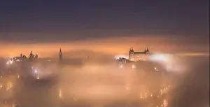 Alcazar Prints: Amazing scenery of shining and luminous ancient Alcazar de Toledo castle over town in misty twilight