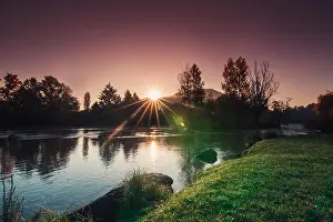 Shimmering Prints: Amazing sunrise by the quiet river with vegetation