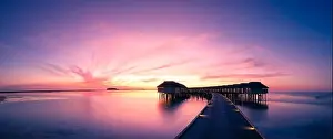 Amazing sunset beach in Maldives, with luxury over water villas and perfect sunset sky. Dreamy summer vacation and holiday concept