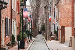 Philly Prints: American and French flags from brick row homes in a narrow street in Philadelphia, USA