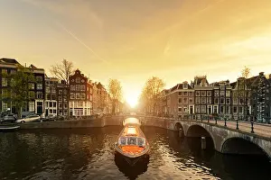 Amsterdam canal cruise ship with Netherlands traditional house in Amsterdam, Netherlands