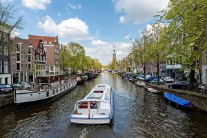 Amsterdam canal cruise ship with Netherlands traditional house in Amsterdam, Netherlands