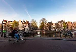 Amsterdam people riding bicycles in historical part in Amsterdam, Netherlands