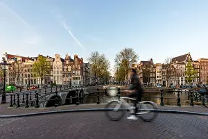 Amsterdam people riding bicycles in historical part in Amsterdam, Netherlands