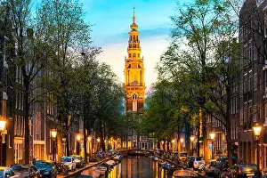 Amsterdam Zuiderkerk church tower at the end of a canal in the city of Amsterdam, Netherlands at night