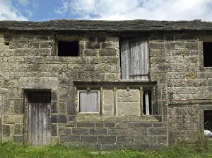 Vacancy Prints: Ancient abandoned stone cottage in a row of rural buildings with empty windows