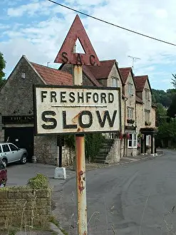 Ancient road sign close to the inn at Freshford , a village in the North of Somerset advising the traffic to slow down.