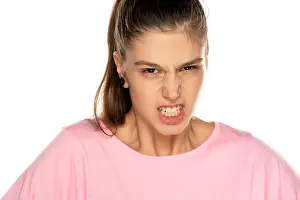 Upset Prints: Angry young woman shows her teeth on white background