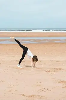Unrecognizable Prints: anonymous teenager doing handstand near sea