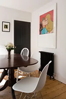 Radiator Prints: Antique mahogany tilt-top table in dining room with white Eames DSR chrome base chairs and pop art the wall