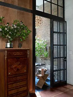 Vertical Image Prints: Antique tall boy cabinet with metallic vase