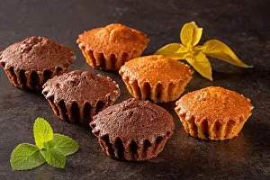 Vanilla Prints: This appealing image features a variety of freshly baked muffins artfully arranged with vibrant green mint leaves