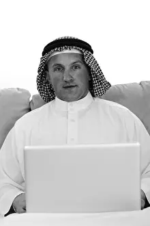 Satisfied Prints: Arabic man using laptop at home