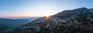Arachova Greece mountain town aerial panoramic view. Traditional houses and stone tower clock at sunset