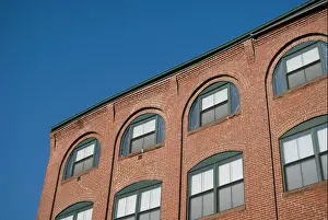 Arched Prints: Arched windows in a brick warehouse wall, against a blue sky