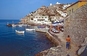 Tanned Prints: Archival image. Returning to the waterfront cafe's at Agia Galini in Crete from the beach in the 1980's