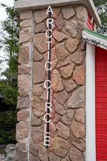 Claus Prints: Arctic Circle crossing sign in Santa Claus Village in Rovaniemi, Finland in summer