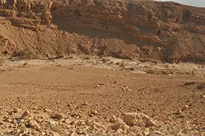 Vastness Prints: An arid landscape features rocky formations and a smooth