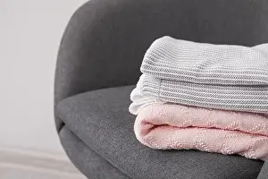 Armchair with warm plaids in room, closeup