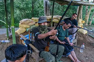 Protecting Prints: An armed Kuki man demonstrates a rifle while guarding the checkpoint at Dampi village in Churachandpur district
